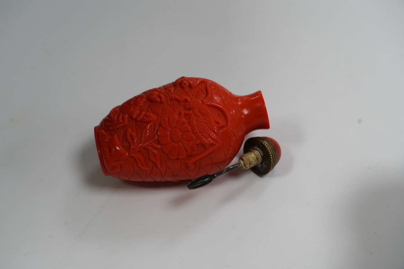 A Chinese coral coloured glass 'crabs' snuff bottle, 8.2cm high. Condition - good